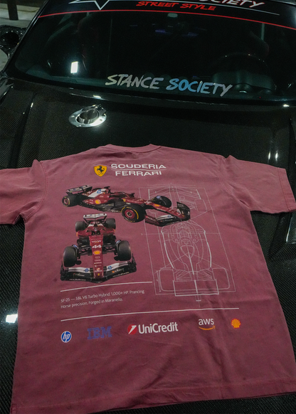 A faded vintage red short-sleeve t-shirt featuring a red Scuderia Ferrari F1 car graphic and sponsor logos, laid flat on a glossy black car hood in front of a windshield with 'STANCE SOCIETY' written on it.